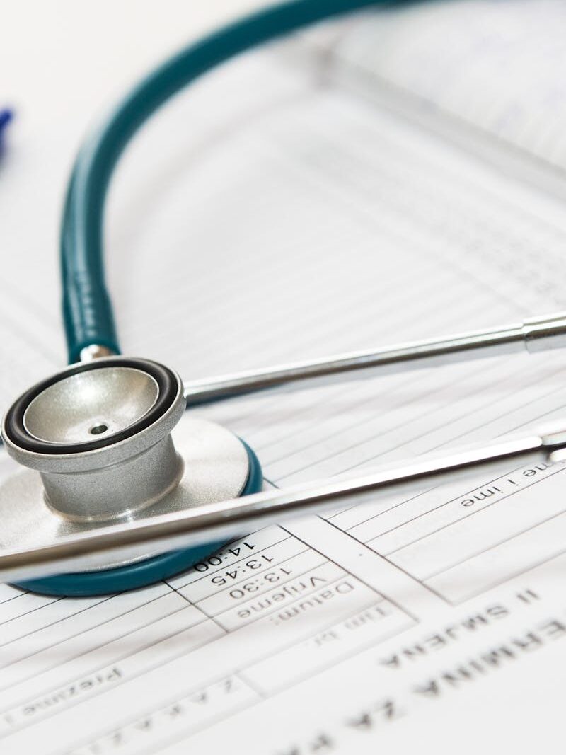 Home A stethoscope and pen resting on a medical report in a healthcare setting.